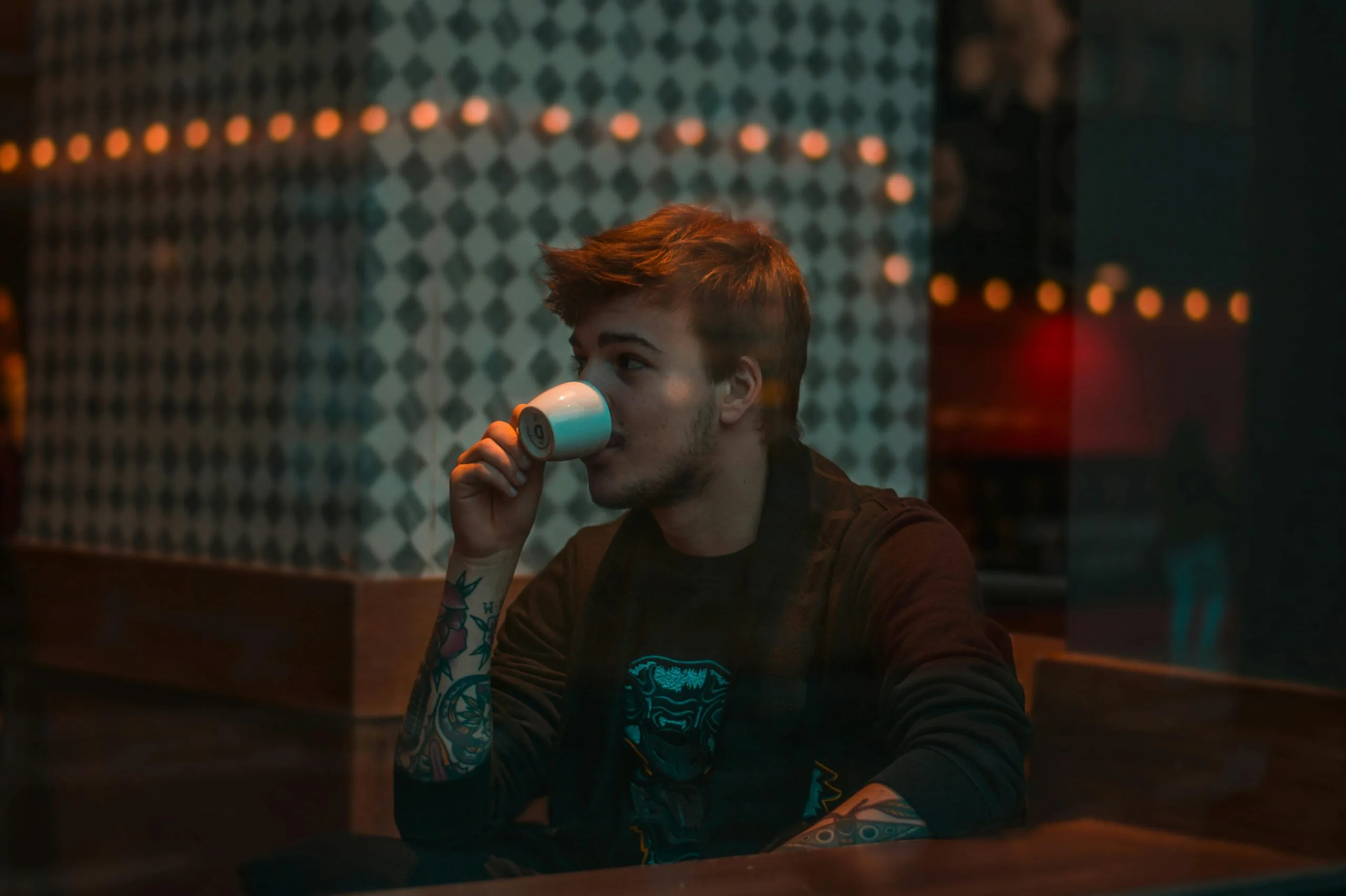 A man thinking how to reach local customers while sitting in a cafe, illustrating the solutions a Freelance Digital Marketing Strategist in Kochi provides for local discoverability.
