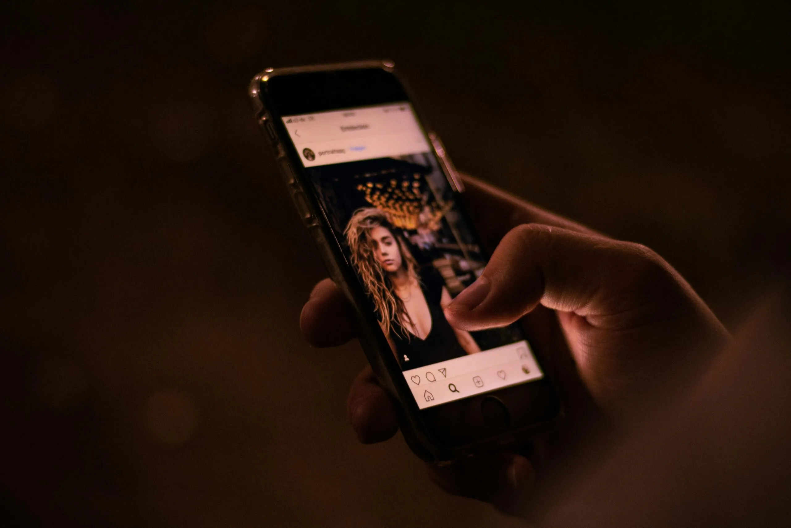 A hand holding a smartphone scrolling through a social media app, illustrating the daily work of a Freelance Digital Marketing Strategist in Kochi to manage and grow social media presence.