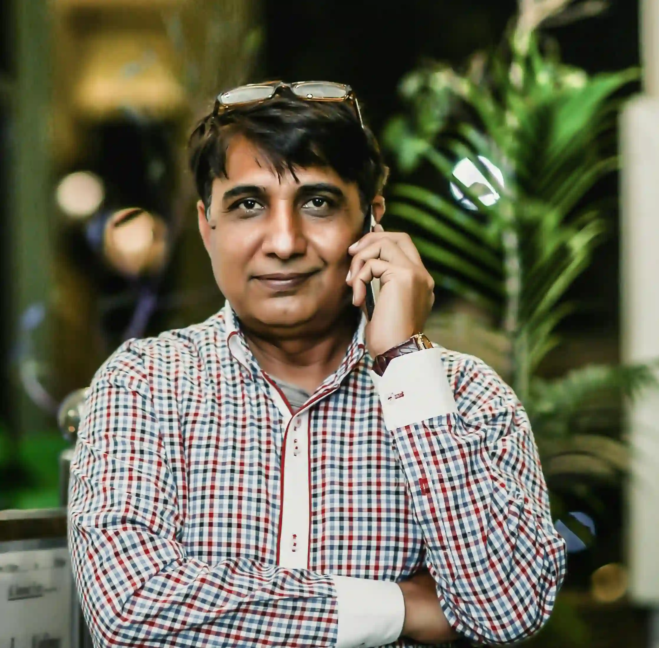 A professional man on a phone call, symbolizing the positive client relationship and successful results from working with a Freelance Digital Marketing Strategist in Kochi.